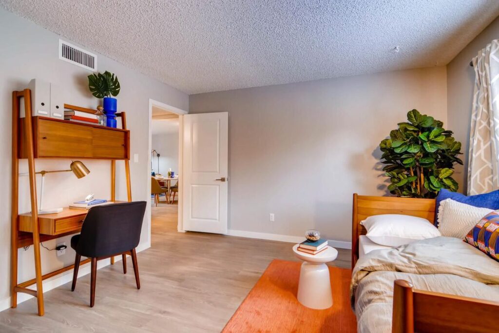 Bedroom staged as an office with desk and sofa