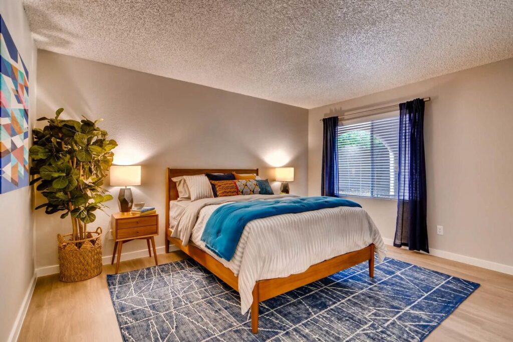 Nice bedroom with a large window at Camelback apartments in Scottsdale.