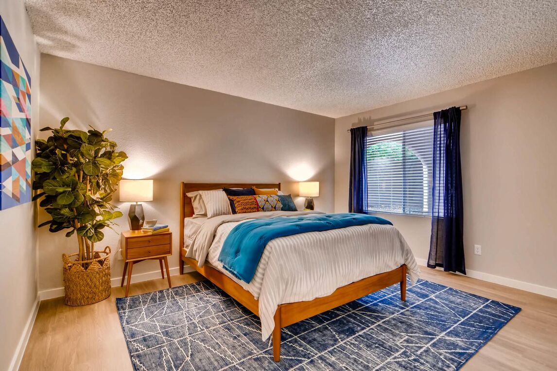 Bedroom with a bed and 2 panel window and blue carpet